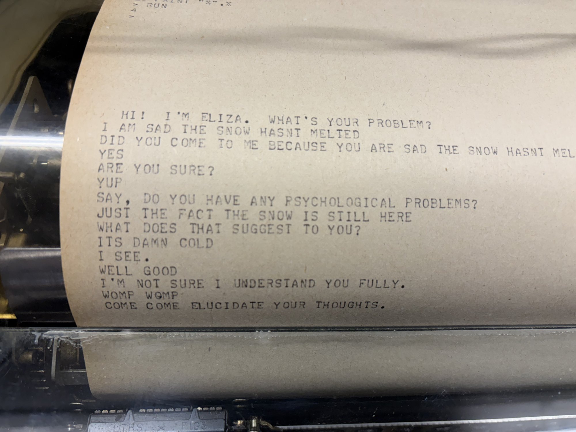 Teletype paper showing an ELIZA conversation about being sad that the snow hasn't melted.